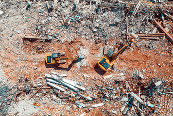 Excavators demolishing old factory for new construction project, aerial top view