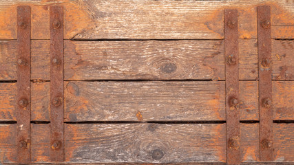 Wooden background. Old boards with metal straps