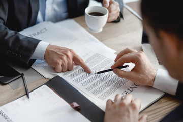 Obraz premium Two men pointing to the paragraph in contract