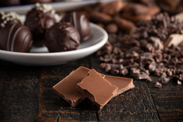A Moody Image of Various Types of Chocolate on a Wooden Table