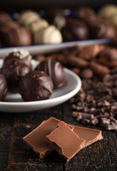 A Moody Image of Various Types of Chocolate on a Wooden Table