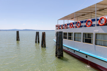 Tourist boat moored on the quay of the lake.