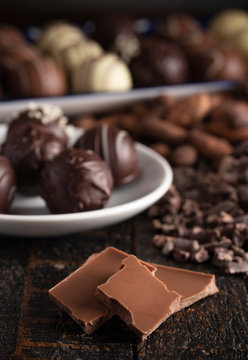A Moody Image of Various Types of Chocolate on a Wooden Table