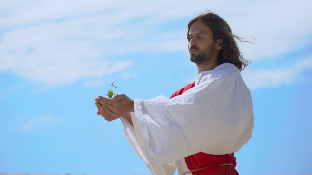 Man Like Jesus Holding Sprout Against Sky, Biblical Story Of World Creation