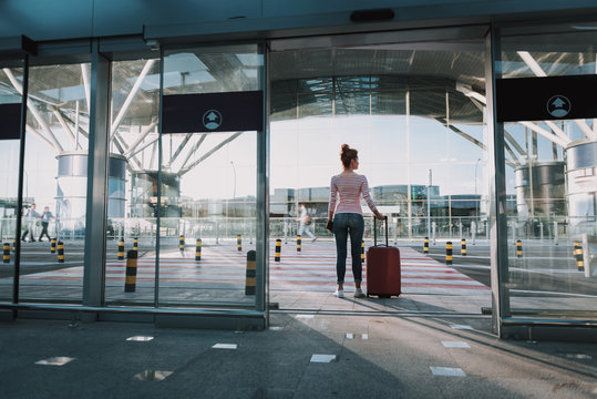 Young woman with travel luggage bag standing in airport
