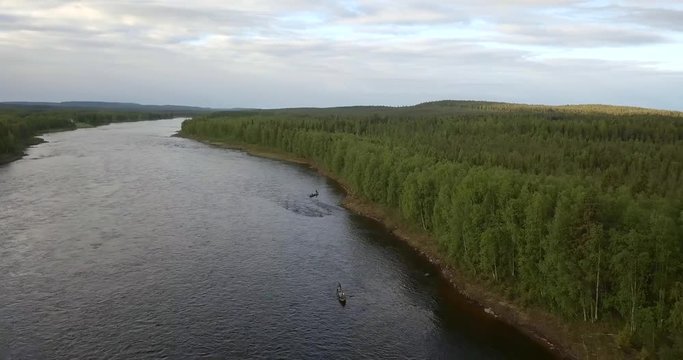 Aerial, drone shot, towards fishing boats on the Tornionjoki river, on a cloudy day, in Pello, Meri-Lappi, Lapland, Finland
