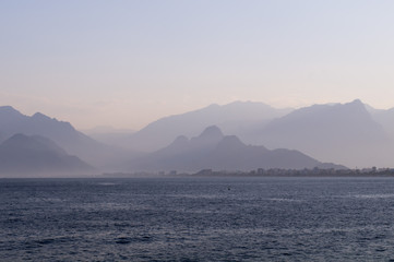 Mountains in a blue haze and sunset over the sea