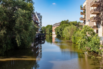 Fototapeta premium View from the river Weisse Elster in Leipzig Schleussig with beautifully restored old and modern houses. This is a nice way for water sports in Leipzig. It is a popular place