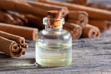 Fototapeta na wymiar A bottle of essential oil with Ceylon cinnamon sticks