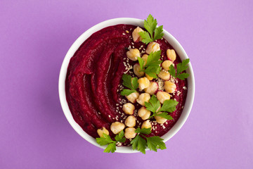 Vegan smoothies bowl with beetroot and chickpea on the violet background.Top view.Copy space.