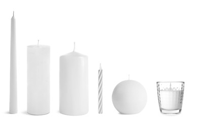 Set with different candles on white background