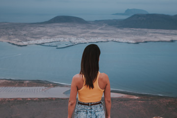 Chica de espaldas mirando a la isla de La Graciosa desde el Mirador del Río