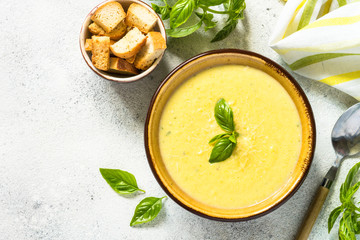 Zucchini Cream soup with basil and croutons on white.