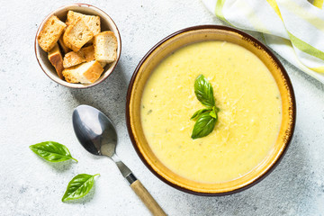 Zucchini Cream soup with basil and croutons on white.