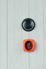 top view of bowl with pet food and empty bowl on wooden surface