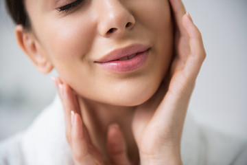 Close up smiling lady enjoying her soft skin