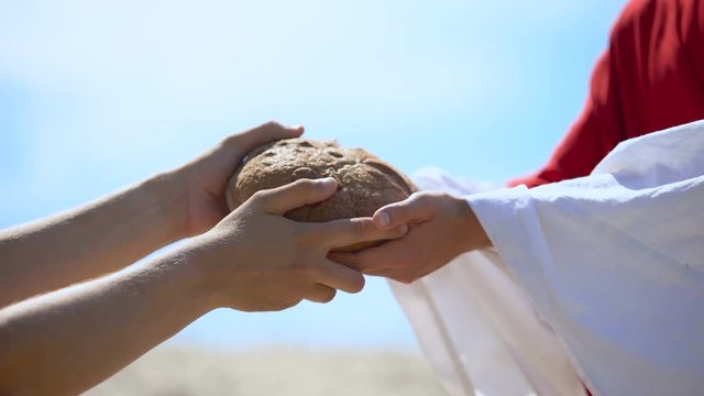 Jesus hands giving bread to poor man, biblical story to feed hungry, charity