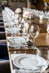 Wine glasses in the foreground. Wedding Banquet or gala dinner. The chairs and table for guests, served with cutlery and crockery.