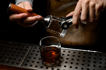 Bartender making a stamp imprint on the big ice cube