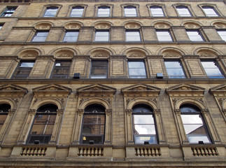 Fototapeta na wymiar the facade of a large stone 19th century commercial building in the little germany area of bradford west yorkshire with ornate neo classical style windows