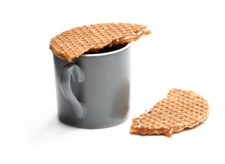 Melted Dutch caramel waffle on cup of coffee isolated on white