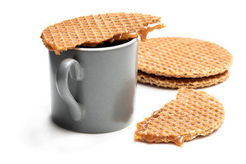 Melted Dutch caramel waffle on cup of coffee isolated on white