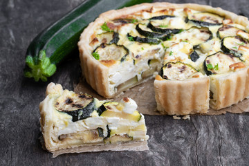 Homemade courgette and feta quiche on rustic wooden table
