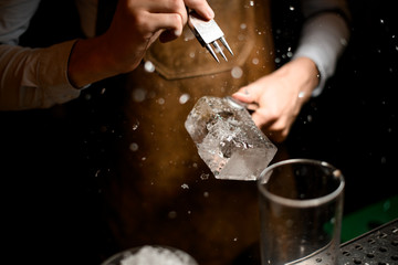 Male bartender making a crushed with a special instrument