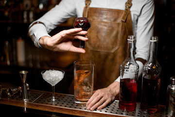 Bartender adding an essence from the little glass bottle
