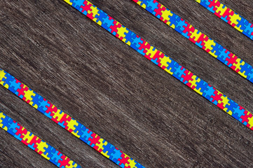 World Autism awareness day with Puzzle ribbon on wooden background