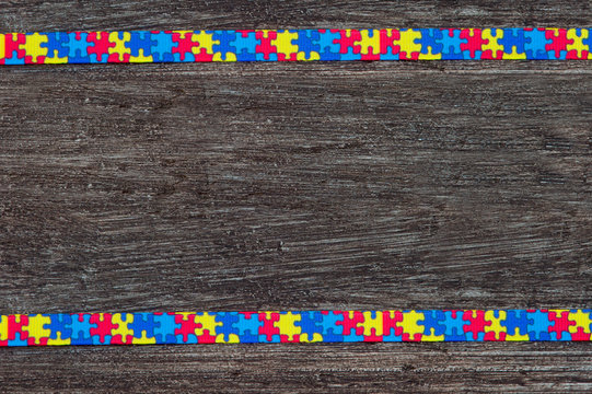 World Autism awareness day with Puzzle ribbon on wooden background