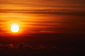Sunrise / sunset over the clouds and horizon in golden colors.