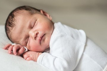 infant newborn baby dressed in white 