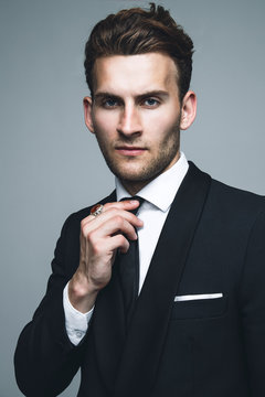 Portrait of young and handsome model in a classic black and white style clothing. Studio shot. Copy space.