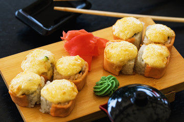 Hot rolls on a wooden stand with ginger and wasabi