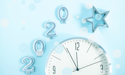 Obraz na płótnie Canvas Happy New Year 2020. Christmas clock and star on pastel blue background. Flat lay, top view, copy space