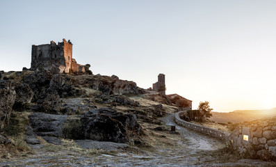 ruined castle at the top of the hill in a sunset