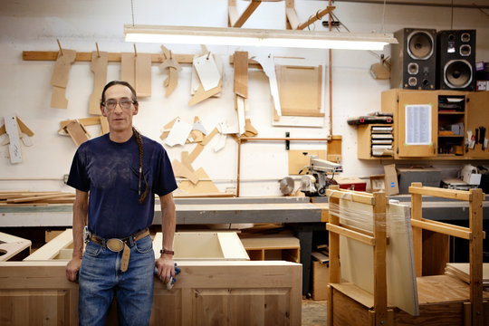 Portrait of carpenter standing in woodshop