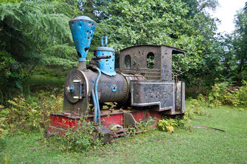 Old rusty abandoned overgrown steam locomotive with bullet holes on the top of Mount Aphon, Abkhazia