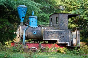 Old rusty abandoned overgrown steam locomotive with bullet holes on the top of Mount Aphon, Abkhazia