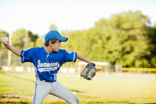 Little league pitcher (8-9) throwing ball