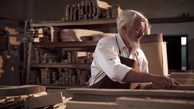 A series of clips of an old retired Wood Carver creating a Furniture from start to finish. He’s Working in big bright Workshop using traditional tools and technique. Handwork. Handcraft. Carpenter.