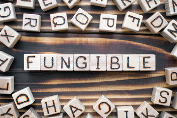 Obraz premium fungible wooden cubes with letters, easy to exchange concept, around the cubes random letters, top view on wooden background