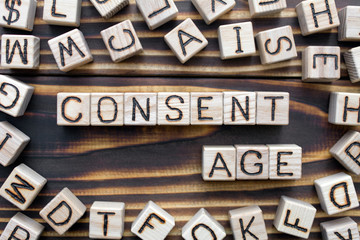 consent age wooden cubes with letters, sexual education concept, around the cubes random letters,...
