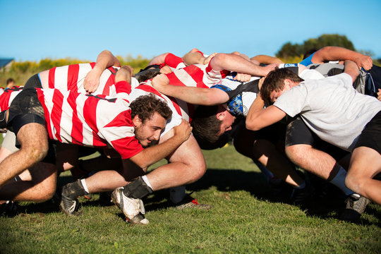 Young men playing rugby in field