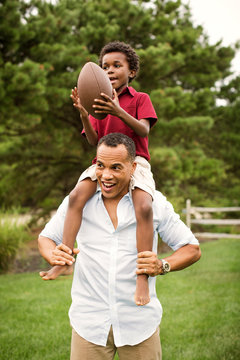 Man carrying his son on shoulder outdoors