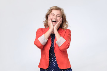 Mature happy woman laughing loudly on joke.