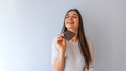  Lovely smiling teenage girl with eyes closed eating chocolate