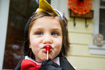 Obraz premium Close up of girl in costume eating lollipop
