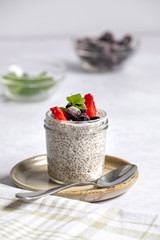 angled view of chia pudding in glass jar with some key ingredients